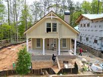 Charming new construction home with a welcoming porch and light-colored siding in a wooded neighborhood at 11792 Serenbe Ln, Chattahoochee Hills, GA 30268