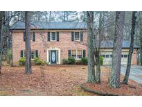 Brick house with attached two-car garage and mature trees at 1920 Shoreline Trce, Grayson, GA 30017