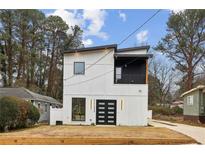 Modern two-story home featuring a sleek black and white design and striking front door at 2208 Baker Nw Rd, Atlanta, GA 30318