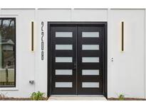 Modern front door with glass panels and stylish lighting fixtures on a white home exterior at 2208 Baker Nw Rd, Atlanta, GA 30318