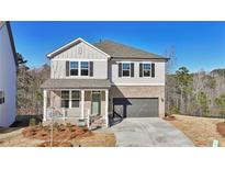 Charming two-story home with brick accents, a covered porch, and a two-car garage, set against a backdrop of trees at 688 Calvet Way, Cumming, GA 30041