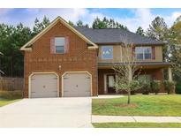 Charming two-story home features a brick facade, two-car garage, and a well-manicured lawn at 7940 White Oak Loop, Lithonia, GA 30038
