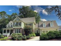Charming two-story home with light green siding, shutters, dormer windows, and professional landscaping at 192 Chicopee Ne Dr, Marietta, GA 30060