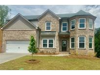 Charming two-story brick home featuring a well-manicured lawn, inviting entrance, and attached two-car garage at 316 Rodeo Dr, Auburn, GA 30011