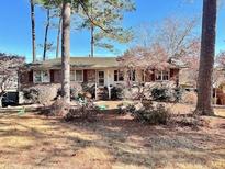 Charming single-story brick home with a well-maintained front yard and mature trees at 3928 Potomac Nw Dr, Kennesaw, GA 30144