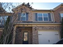 Brick front elevation of a two-story townhome with a two-car garage at 7765 Haynes Park Cir, Lithonia, GA 30038