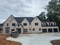 Elegant, newly built home showcases a light brick exterior, black trim and a three-car garage at 839 Braselton Hwy, Lawrenceville, GA 30043