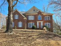 Brick two-story house with a large front yard and mature trees at 1340 Cascade Falls Sw Dr, Atlanta, GA 30311