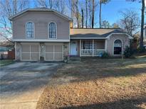 Charming two-story home featuring a welcoming front porch and a two car garage at 3576 Highland Pine Way, Duluth, GA 30096