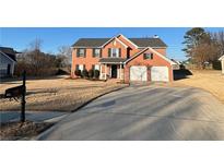 Two-story brick home featuring an attached two-car garage and well-manicured landscaping at 575 Dunagan Dr, Lawrenceville, GA 30045