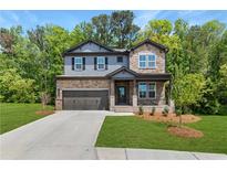 Charming two-story home featuring stone and siding exterior, manicured lawn and attached two-car garage at 4002 Adler Cir, Buford, GA 30519