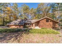 Brick and wood house with large windows, nestled in a wooded setting at 2612 Country Club Se Dr, Conyers, GA 30013