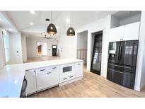 Modern white kitchen with island, stainless steel appliances, and hardwood floors at 707 Erin Sw Ave, Atlanta, GA 30310
