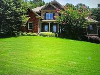 Brick home with stone accents, lush lawn, and mature trees at 5040 Wildeoak Trl, Douglasville, GA 30135