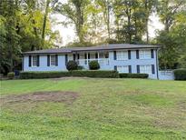 Charming single-story home features a light brick facade, black shutters, and a neatly landscaped front yard at 2418 Brookdale Ne Dr, Atlanta, GA 30345