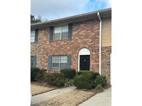 Brick townhouse exterior with landscaping and a black front door at 61 Northdale Pl, Lawrenceville, GA 30046
