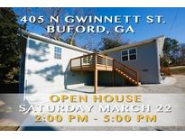 Charming home featuring an open house with large wooden deck and manicured lawn at 405 N Gwinnett St, Buford, GA 30518