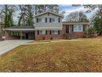 Ranch style home with brick and gray siding, carport, and landscaped lawn at 3293 Hobart Nw Dr, Atlanta, GA 30318
