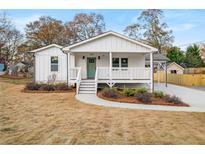Charming craftsman home featuring white siding, a welcoming front porch, and a well-manicured lawn at 1009 Manor Se Dr, Smyrna, GA 30080