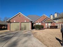 Brick house with three-car garage and mature landscaping at 3747 Misty Wood Nw Dr, Marietta, GA 30064
