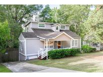 Charming house with gray siding, a white porch, and a well-maintained lawn at 1390 Almont Sw Dr, Atlanta, GA 30310