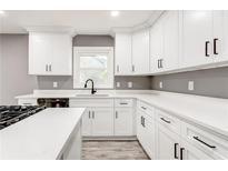 Bright kitchen features white cabinets, modern black hardware, quartz countertops, and stainless steel appliances at 2216 Golden Dawn Sw Dr, Atlanta, GA 30311