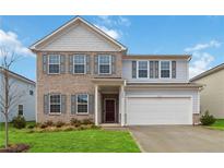 Two-story house with brick and siding, gray shutters, and a two-car garage at 340 Paulownia Cir, Mcdonough, GA 30253