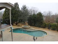 Backyard pool with a stone surround and attached jacuzzi, perfect for outdoor relaxation and entertainment at 3166 Sable Ridge Dr, Buford, GA 30519