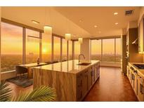 Modern kitchen features a marble island, stainless steel appliances, and a stunning city view at sunset at 3630 Peachtree Ne Rd # 2207, Atlanta, GA 30326