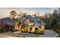 Beautiful two-story home with a well-manicured lawn and detailed stonework, enhancing its curb appeal at 1125 Lake Shore Overlook, Alpharetta, GA 30005