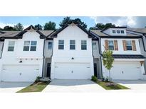 Three-unit townhome building; white exterior, dark trim, two-car garages at 399 Auburn Valley Way, Auburn, GA 30011