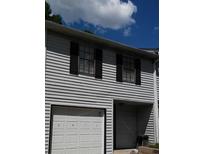 Two-story townhome with gray siding, white garage door, and black shutters at 2511 Pine Tree Trl, Atlanta, GA 30349