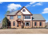 Charming two-story brick home with a gabled roof, shutters, and a well-manicured lawn at 416 Telfair Way, Canton, GA 30115