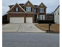 Two story brick house with three car garage and manicured lawn at 7413 Melhana Ln, Union City, GA 30291