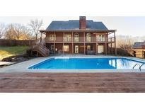 Stunning backyard with large in-ground pool, deck, and two story brick home with balconies at 116 Big Cotton Trl, Mcdonough, GA 30252