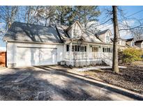 White two-story house with a wraparound porch and attached garage at 3979 Doral Cir, Atlanta, GA 30360