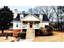 Charming raised ranch home with a red door and wrap-around porch at 4045 Mark Todd Ct, Hoschton, GA 30548