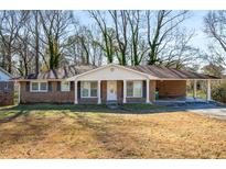 Brick ranch house with covered porch and large yard at 1801 Se Caribaea Se Trl, Atlanta, GA 30316