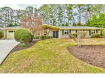 Charming ranch-style home featuring a stone accent wall, manicured lawn, and mature landscaping at 1195 Fielding Way, Marietta, GA 30068