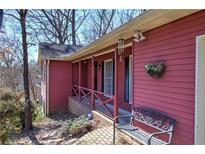 Ranch home with red siding, covered porch, and a brick walkway at 731 Willow Ridge Dr, Marietta, GA 30068