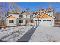 Two-story house with a three-car garage and wood accents at 4571 Deep Creek Dr, Sugar Hill, GA 30518