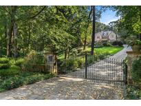 Estate home featuring an inviting gated entry, long driveway, and lush, mature landscaping at 4345 Mount Paran Nw Pkwy, Atlanta, GA 30327