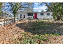 Charming ranch home with red door and fenced yard at 5904 Heatherwood Ln, Riverdale, GA 30296