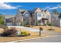 Brick front exterior of a two-story house with a three-car garage and manicured landscaping at 4851 Hanalei Holw, Suwanee, GA 30024