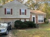 Two-story house with attached garage and landscaping at 1975 Longwood Ct, Lithonia, GA 30058