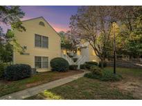 Evening view of a yellow two-story building with stairs and landscaping at 918 Cannongate Sw Xing, Marietta, GA 30064