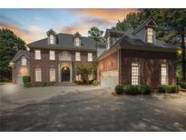 Brick house with a circular driveway and landscaping at 1446 W Wesley Nw Rd, Atlanta, GA 30327