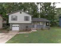 Cozy ranch home with a stone facade, attached garage, and a covered porch at 2125 Jessica Way, Lithonia, GA 30058