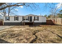 Single-wide mobile home with a deck and fenced yard at 740 Smith Ferguson Rd, Dallas, GA 30157