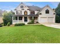 Charming two-story brick home featuring a welcoming front porch and a well-manicured lawn at 3714 Thunder Ne Way, Marietta, GA 30066